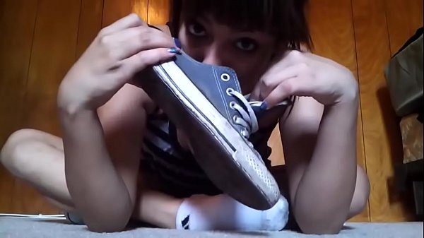 Hermosa chica se quita las converse y los calcetines para mostrar sus ricos pies sudorosos.